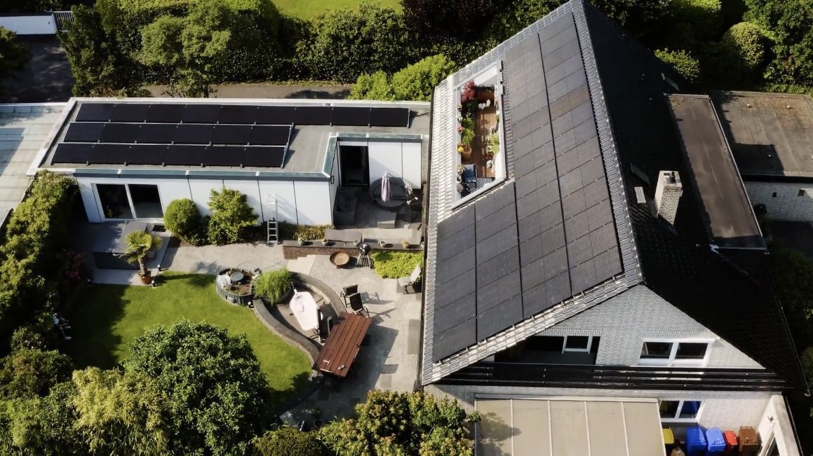 Ein Haus aus der Luftaufnahme mit einer Photovoltaikanlage auf dem Dach
